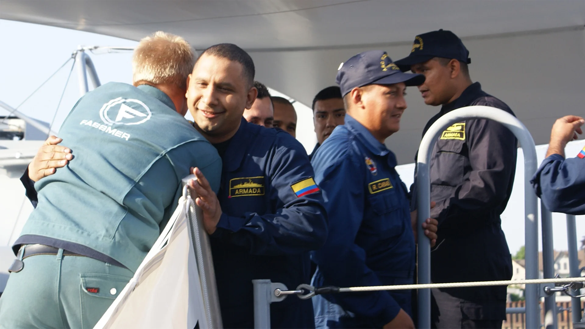 Fassmer Defence technology transfer: employee welcoming Colombian Navy officers on board, symbol of international cooperation