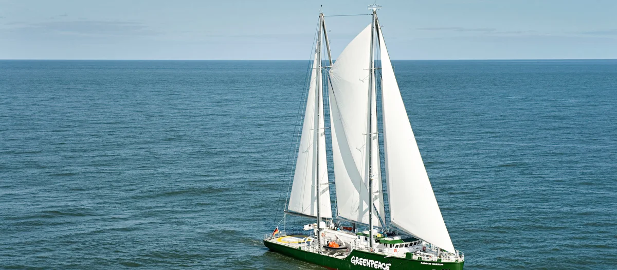Sailing ship Rainbow Warrior III by Greenpeace on the open sea. Built by Fassmer in 2011, this three-masted schooner was the first vessel designed specifically for Greenpeace, supporting research, campaigns, and sustainable ocean operations.