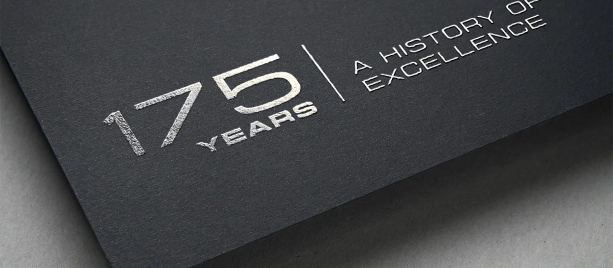 Close-up of a dark card with silver embossing showing the Fassmer anniversary logo: “175 Years | A History of Excellence.” Symbol of 175 years of Fassmer tradition, innovation, and excellence in shipbuilding and composite technology.