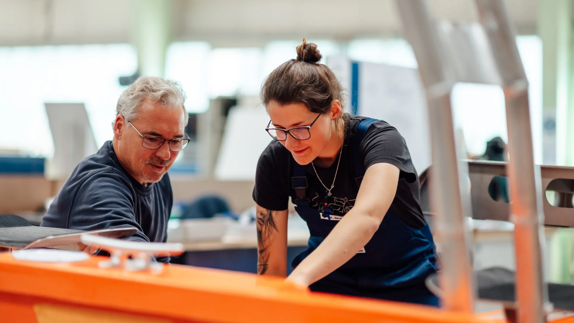 Two Fassmer employees working together on a shipbuilding component in the shipyard. Teamwork and hands-on experience in shipbuilding.