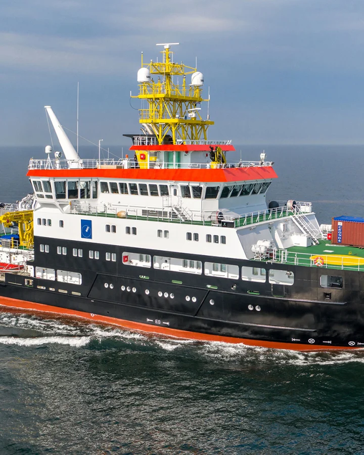The 75-meter survey, wreck search, and research vessel Atair at sea, equipped with yellow cranes and a prominent bridge structure.