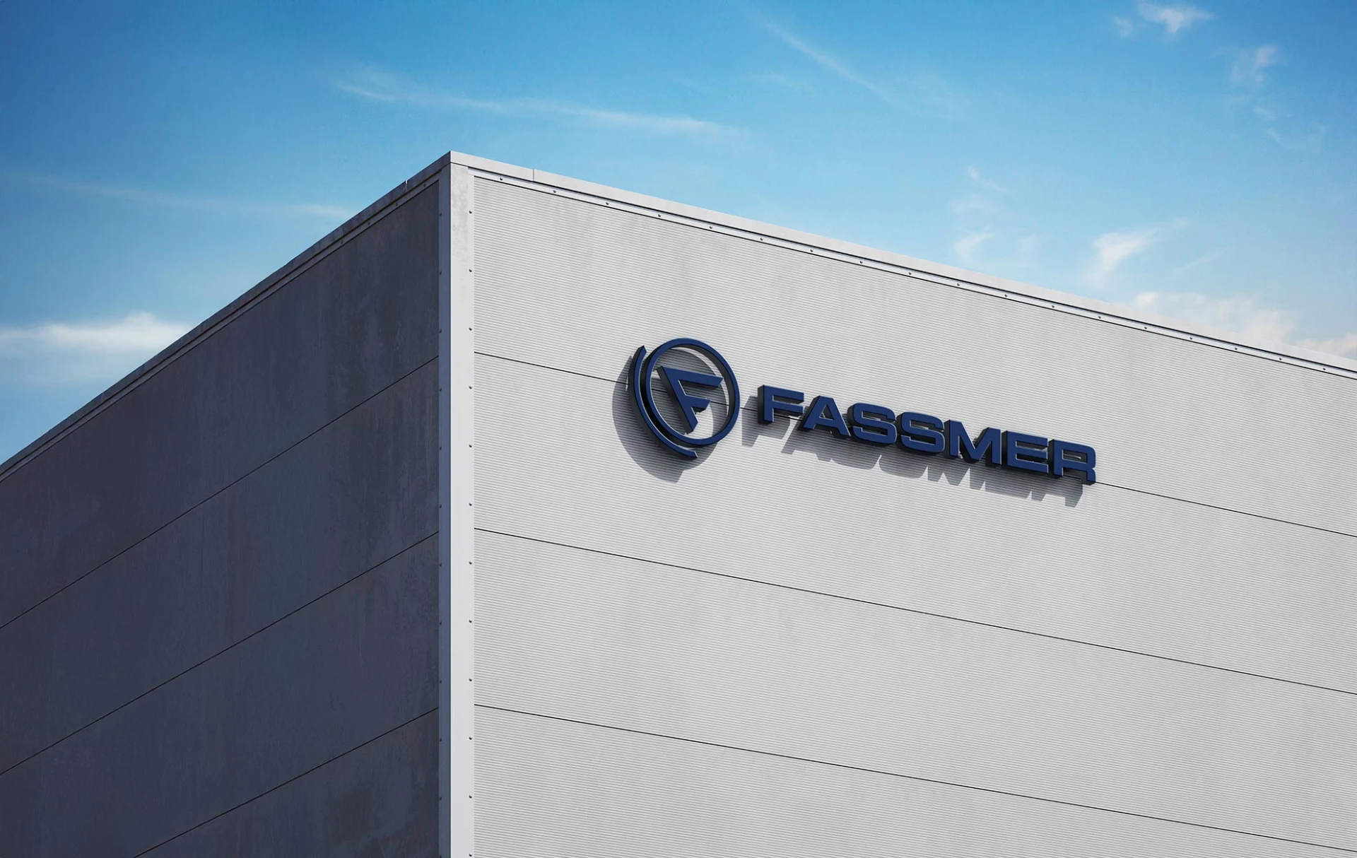 Fassmer company building in Berne with blue Fassmer logo on the facade against a blue sky.“
